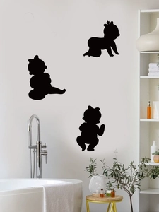 Detailed view of three black baby silhouette wall stickers on a modern bathroom wall