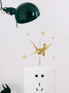 Detailed view of 3D origami crane wall sticker with gold stars and tassel on white wall