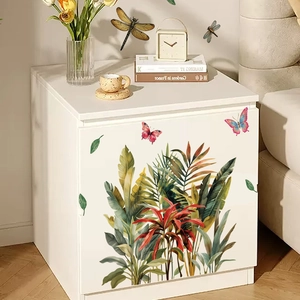 Tropical green plant wall decal with butterflies and dragonflies on a white nightstand