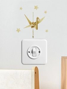 Golden origami crane wall sticker with stars decoration above white light switch