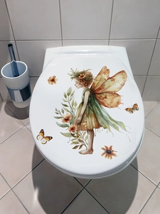Macro detail of waterproof PVC toilet lid sticker with forest fairy and butterflies