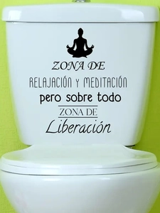 Detail of black vinyl yoga meditation sticker on a white toilet tank with Spanish text