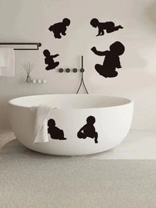 Detailed view of black baby silhouette wall stickers in various crawling poses in a bathroom