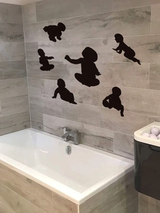 Detail of black crawling baby silhouette wall stickers on bathroom tile wall