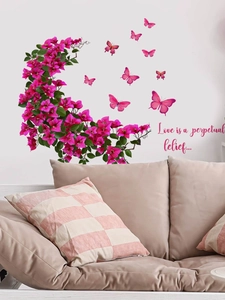 Détail de stickers muraux fleurs roses avec papillons et citation dans un salon