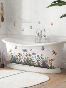Waterproof floral and butterfly wall decals applied on a white bathtub and marble tiles