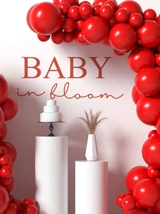 Detail of red balloon arch kit with Baby in Bloom signage for shower wall decor