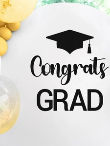 Close-up of graduation wall decal with black Congrats GRAD text and golden balloons