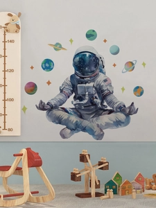 Detail of astronaut and planets wall decal set in a cozy modern nursery room setting