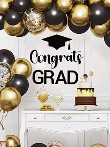 Detail of gold and black balloon arch with Congrats GRAD sticker for graduation party decor