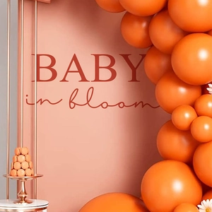 Baby in Bloom shower party decor with orange balloon arch and wall backdrop signs