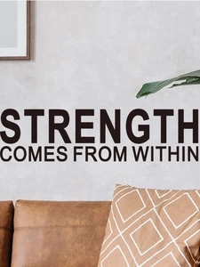 Detail showing 'Strength comes from within' wall decal above a sofa in a modern room decor