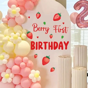 Strawberry first birthday party arch decal with pink balloons and berry decorations