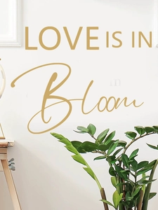 Dettaglio dell'adesivo murale dorato Love is in Bloom per decorazioni da festa nuziale