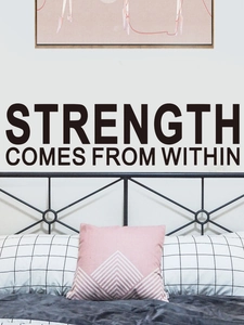 Detailed view of black inspirational quote wall sticker above a bed in bedroom