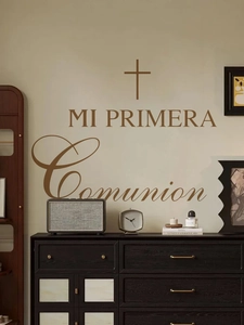 Détail de l'autocollant mural Mi Primera Comunion avec croix sur un mur décoratif beige