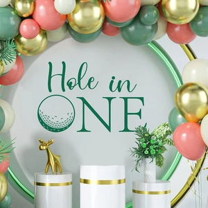 Hole in One golf birthday party backdrop with green balloons and gold decorations
