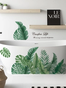 Detail of tropical monstera leaf wall stickers with Carefree Life text on white wall