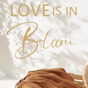 Adesivo Love in Bloom su pregiato tessuto di lino drappeggiato su sedia in vimini