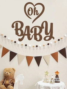 Détail de fanions en feutre aux tons terre et guirlande de boules pour baby shower