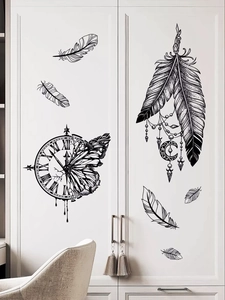 Detail of vintage clock and feather wall stickers on white wardrobe door surface