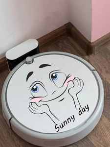 Détail d'un visage de dessin animé timide et texte Sunny Day sur un robot aspirateur