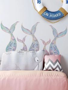 Detail of dreamlike mermaid tail wall decals with glitter scales in a cozy kid room