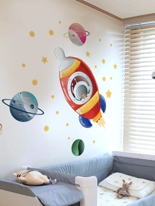 Détail de stickers muraux espace avec fusée et étoiles dans une chambre d'enfant douillette