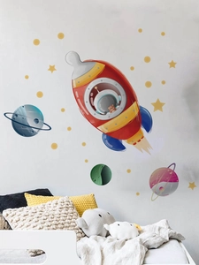 Détail d'autocollants muraux fusée et planète sur un mur blanc de chambre d'enfant