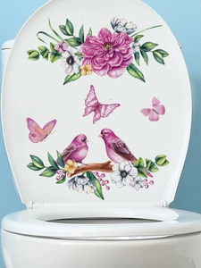 Close-up of pink flower, bird and butterfly stickers on a white toilet lid cover