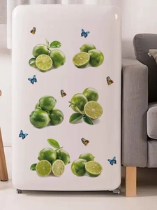 Detail showing green lemon and butterfly stickers on a white refrigerator door