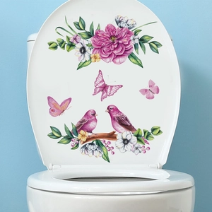 Pink floral wall decals with birds and butterflies on white bathroom toilet lid