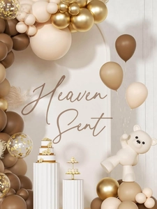 Detailed heaven sent party decor with brown and gold balloons and cute bear statue