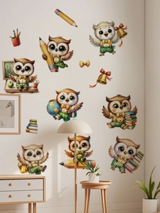 Detailed view of cute cartoon owl wall decals with school supplies on a white bedroom wall