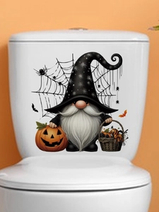 Detail of Halloween gnome sticker on toilet tank with pumpkin and spider web decor