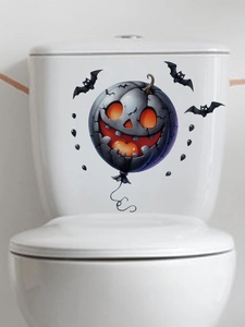 Detail of grey pumpkin balloon and black bats stickers applied on white toilet tank surface