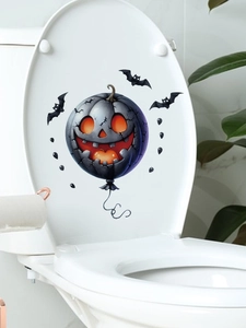 Detail of Halloween pumpkin balloon and bats decal applied on white toilet lid surface