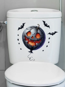 Detail view of spooky Halloween pumpkin and bat stickers on a white toilet tank