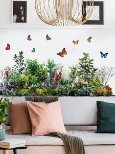 Detail-Wandtattoo mit bunten Schmetterlingen und grünen Blättern über einem weißen Sofa