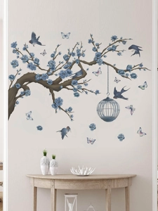 Detail of floral wall sticker with blue blossoms birdcage and birds on white wall