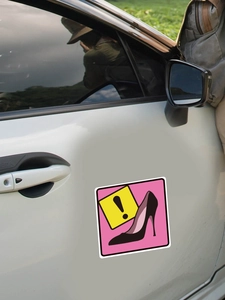 Magnetic car sticker showing black high heel silhouette and yellow exclamation mark warning