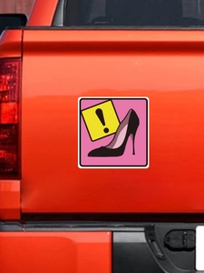 Close-up of a pink high heel and exclamation mark sticker on a red pickup truck tailgate