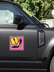 Close-up of pink high heel and exclamation mark PVC car decal on a matte black door