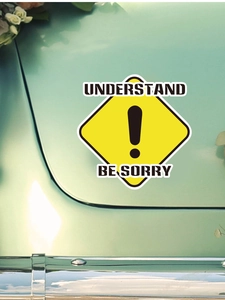 Detail of yellow diamond road sign sticker with text on a light green car surface