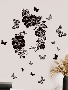 Close-up of black rose and butterfly wall decals on a soft beige living room wall