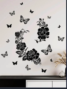 Detail of matte black floral wall stickers featuring roses and butterflies on white wall