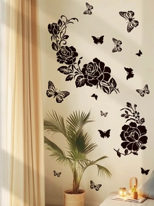 Detailed view of black floral rose and butterfly PVC wall decals in a warm living room