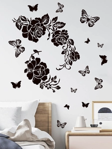 Detailed view of black floral wall stickers and butterfly silhouettes on white bedroom wall