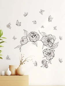 Detail of minimalist black flower wall stickers with butterfly accents in living room decor