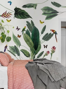 Detail showing tropical green leaves and parrot wall stickers in a bedroom setting